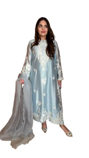 Amna Omar, Founder of Amna Omar Clothing, wearing a light blue embroidered silk suit Amna Omar, Founder of Amna Omar Clothing, wearing a light blue embroidered silk suit