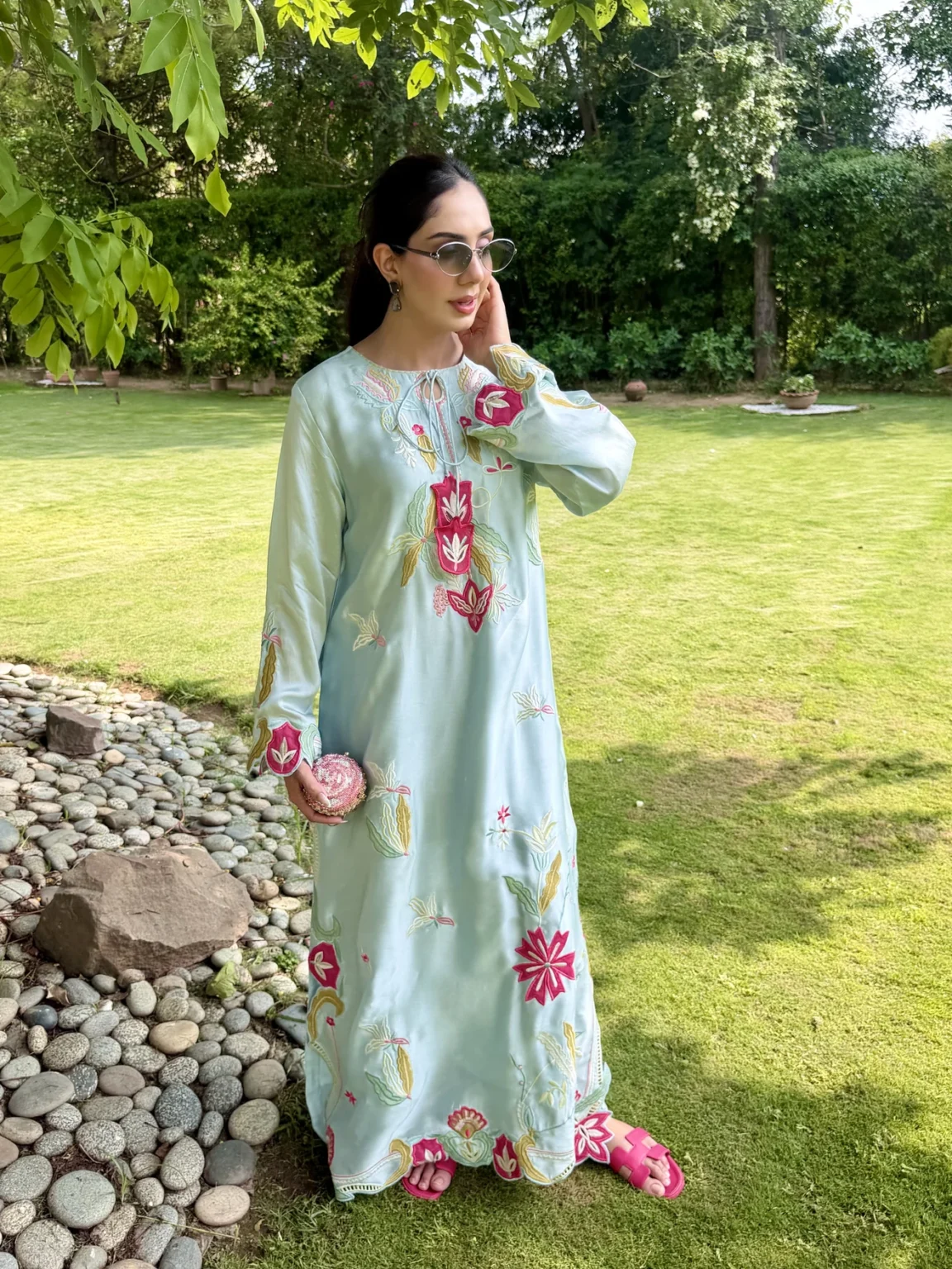Ankle-length pale aqua silk kaftan with a tie neck, fuchsia flowers between mustard and sage leaves down the front, a fuchsia motif at each cuff, and a scalloped hem with a band of openwork